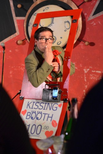 Mark Gindick plays a clown with a kissing booth.