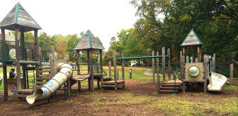 The old playground equipment featured graffiti and rotting wood.