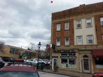 A red balloon attached to the Village Coffee building, which allegedly shows the proposed height (53') of the new Post Office building. 