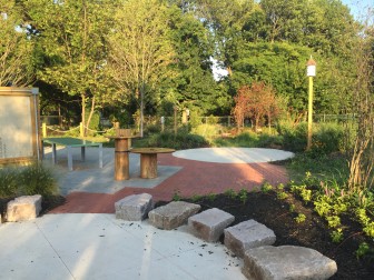The performance circle (foreground), art circle with mist sprayer (middle ground), and habitat garden (back). The brick apron, with inscriptions from donors, provides the transition to the classroom (left, partial view).