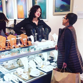 A customer discussing jewelry with designer Elina Bromberg at The Tenth Muse Gallery