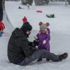 Man and child playing in snow